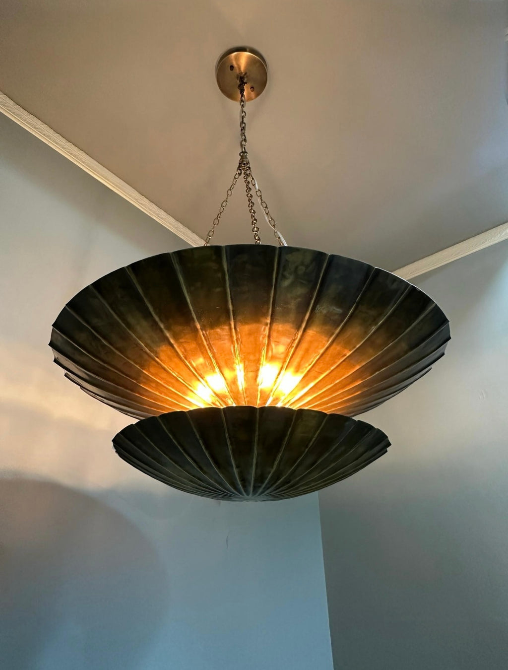 Antique brass double dome pendant light illuminated in interior