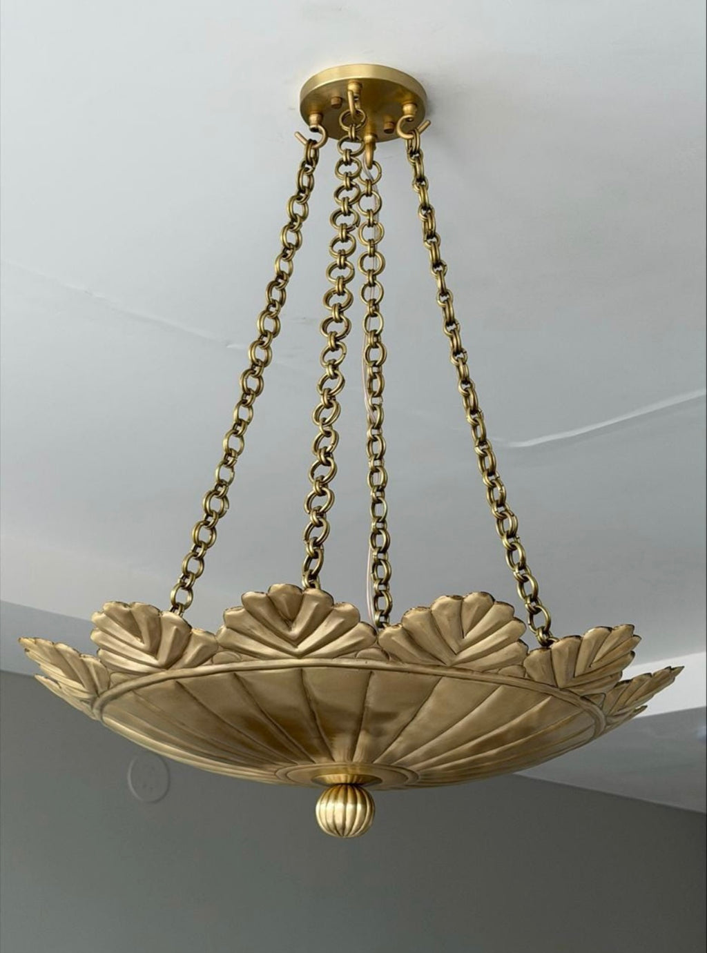 Brushed brass scallop pendant light hanging from chain