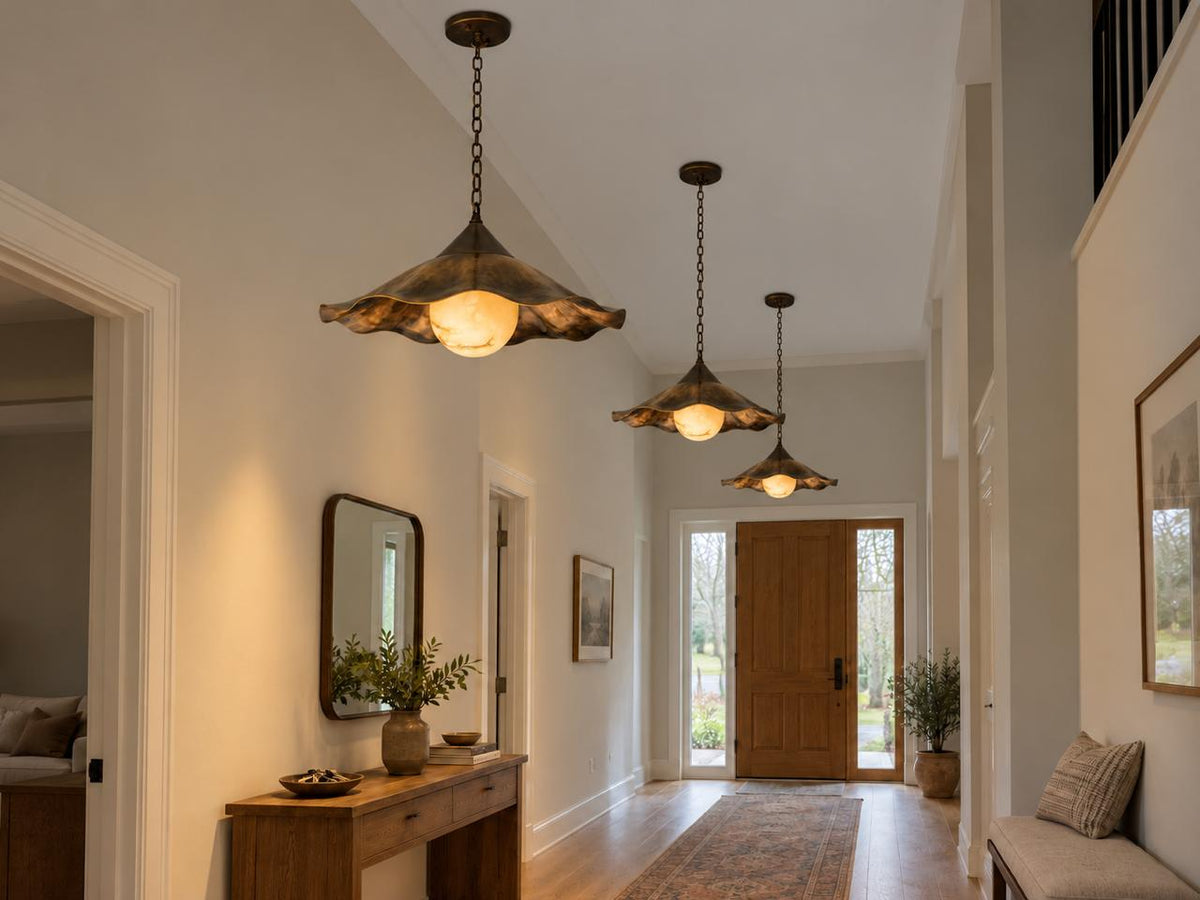 Scalloped brass pendant light glowing warm light in entryway